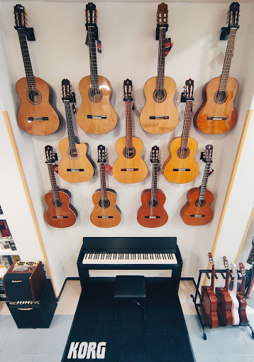 Interior de la tienda von una selección de guitarras, piano y amplificadora